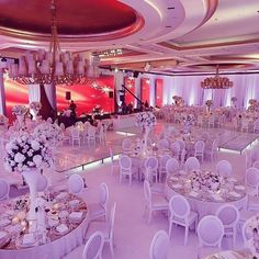 a banquet hall with tables, chairs and chandeliers set up for an event