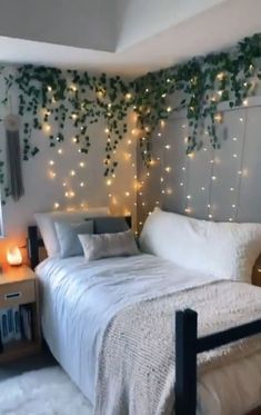 a bedroom with white bedding and lights on the wall