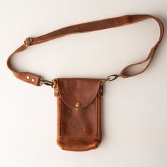 All leather belt bag with adjustable, removable belt strap, phone pocket, interior credit card/ID card pocket, and snap closure.  Perfect for keeping things to a minimum - phone, keys, cash, and a couple of cards.   SIZE 8" high x 5" wide x 1 3/4" deep Detachable & Adjustable Belt Strap: 1" wide Will fit waist measurements from 30 inches to 54 inches. MATERIALS Genuine Kodiak Leather Antique brass hardware Interior leather pocket ONE OF A KIND Leather is natural and unique, adding character & making each product imperfectly beautiful. Each piece is a handcrafted one-of-a-kind piece. The bag you receive will differ from the photograph, but we will ensure that yours is just as beautiful. ABOUT US Frankie & Co. is a leather goods brand focused on quality and craftsmanship. Our products are ha Everyday Carry Crossbody Belt Bag For Mobile Phone, Brown Belt Bag With Cell Phone Pocket For Everyday, Brown Belt Bag With Adjustable Strap For Everyday, Brown Belt Bag With Belt Loops For Everyday Use, Brown Belt Bag With Removable Pouch For Everyday Carry, Leather Belt Bag With Belt Clip For Travel, Brown Belt Bag With Belt Clip For Daily Use, Functional Brown Leather Phone Bag, Functional Brown Phone Bag For Everyday Use