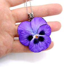 Pansies necklace from polymer clay . Get into the spirit of springtime any time of year with this charming Pansy necklace. A symbol of free-spiritedness and tender affection, this Pansy pendant captures the beauty of real pansies in an easy-to-wear piece of art. Each petal retains its vibrant purple hues, creating a pansy eye jewelry piece that is more than just a fashion statement - it's a statement of the soul. Dare to express yourself with jewelry that speaks to nature's unique craftsmanship. Purple Flower-shaped Whimsical Jewelry, Whimsical Purple Flower Jewelry, Whimsical Purple Flower-shaped Jewelry, Whimsical Flower Pendant Necklace Gift, Whimsical Flower Pendant Necklace As Gift, Whimsical Flower Pendant Necklace For Gift, Purple Jewelry With Flower Charm For Mother's Day, Purple Flower Nature-inspired Jewelry, Nature-inspired Purple Flower Jewelry