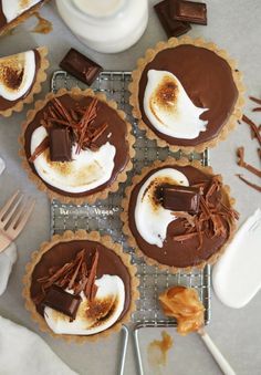 chocolate tarts with marshmallows on a cooling rack and forks next to them