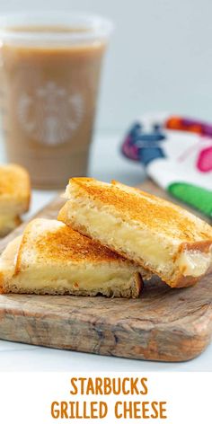 two grilled cheese sandwiches on a cutting board with a cup of coffee in the background