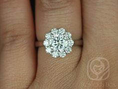 a woman's hand with a diamond ring on her left hand and the center stone is