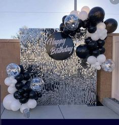 black and white balloon arch with happy birthday sign