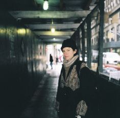 a woman is standing in an empty subway station