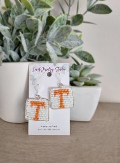 Show your Volunteer pride with these handcrafted Beaded Tennessee Vols Earrings! Featuring the iconic orange 'T' design, these earrings are wire wrapped and silver plated, making them the perfect accessory for any true Tennessee fan. Whether you're gearing up for game day or adding a touch of team spirit to your everyday look, these earrings are a must-have. Handmade with Care: Each pair of these Tennessee Vols Earrings is carefully handcrafted, making every piece truly one-of-a-kind. Due to the handmade nature, the shape may vary slightly from the pictures, adding to their unique charm. Additionally, please note that colors may vary slightly depending on your screen and lighting settings. How to Care for Gold and Silver Plated Jewelry: To keep your gold and silver plated jewelry looking i Tennessee Vols, Glass Beads Jewelry, Jewelry Studio, Silver Plated Jewelry, Wrapped Jewelry, Plated Jewelry, Jewelry Silver, Jewelry Earrings Hoops, Unique Charms