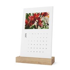 a wooden stand with a calendar on it that is displaying an image of red flowers