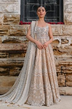 Desert Sand Tissue Pishwas. Embrace the elegance of Anarkali dresses, Pishwas dresses, Pakistani Anarkali dresses, Designer Anarkali dresses, Bollywood Anarkali dresses, Anarkali suits, Anarkali frocks, Anarkali gowns, Traditional Anarkali dresses, and Bridal Pishwas. Elevate your style with this embroidered Anarkali dress.In the warm embrace of desert sand, this exquisite pishwas unfolds, becoming a timeless embodiment of charm and grace. Crafted from the delicate texture of tissue fabric, the pishwas is adorned with intricate eyelet details, floral embroidery, and mirror work, elevating its allure to new heights. With full sleeves and a U-neckline, this pishwas captures the essence of traditional Anarkali dresses, making it a perfect choice for various occasions.Completing the ensemble i Traditional Anarkali Dresses, Gowns Traditional, Traditional Anarkali, Dresses Anarkali, Bollywood Anarkali, Pakistani Anarkali, Bridal Anarkali, Anarkali Frock, Brocade Lehenga