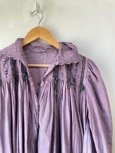 Vintage Purple Victorian Nightgown. Lace-trimmed nightgown with bow details and puffy sleeves that make you feel like you're in a haunted 1920s mansion. The collar has black details that bring out the lacey designs. In good vintage condition with a few missing buttons (sold as is). Fits like a S/M. Feels like cotton/linen. Approx. Measurements: Underarm to underarm: 18" Length: 55" Long Sleeve Victorian Cottagecore Dress, Cottagecore Victorian Dress With Lace Trim And Long Sleeves, Peasant Style Victorian Dress For Daywear, Long Sleeve Victorian Dress For Daywear In Cottagecore Style, Daywear Victorian Dress With Lace Patchwork, Regency Style Long Sleeve Vintage Dress For Daywear, Long Sleeve Cotton Victorian Dress With Lace Trim, Long Sleeve Lace Trim Dress For Night, Cotton Victorian Dress With Lace Trim