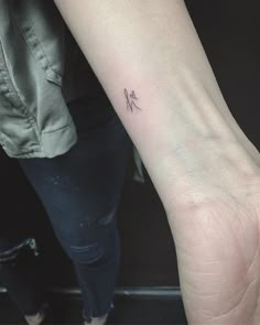 a woman's arm with a small tattoo on the left side of her wrist