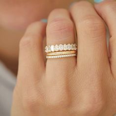 a woman's hand with a gold and diamond ring