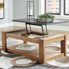 a living room with a coffee table and rugs on the floor in front of windows