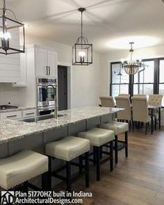 a large kitchen with an island in the middle and lots of counter space on one side