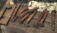 old rusty nails are sitting on a wooden bench