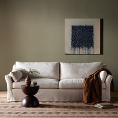 a living room with a white couch and brown table