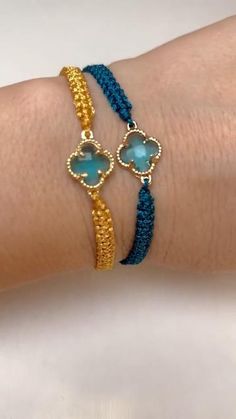 a woman's arm wearing two bracelets with blue beads and gold clasps