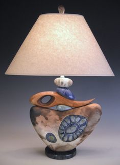 a table lamp with a blue and white design on the base next to a light shade