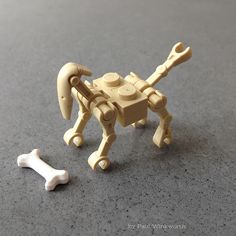 a lego dog with a bone in front of it