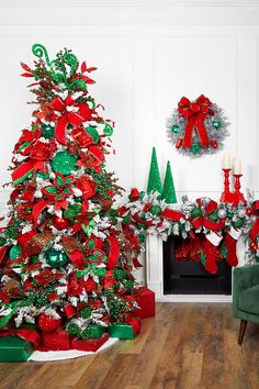 a decorated christmas tree in front of a fireplace with red and green decorations on it