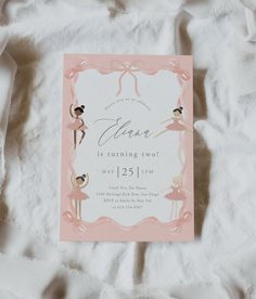 a pink and white ballerina birthday party card on top of a bed covered in sheets