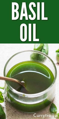 basil oil in a small glass bowl with green leaves around it and the words basil oil on top