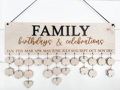 a wooden sign that says family birthdays and celebrations with hearts hanging from the strings