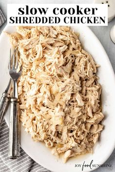 slow cooker shredded chicken on a white plate with fork and spoon next to it