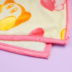 a pink blanket with an image of a cartoon character on the front and back of it