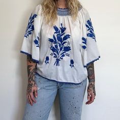 70s Vintage White and blue embroidered blouse with floral design. 100% cotton. Great oversized or fitted. Small snags on the sleeve. Wide billowy sleeves. Good vintage condition. Size Medium to Large. Measured Flat  Chest 21.5" Length 23"  Sleeve length 16" Sleeve opening 12" Model is 5'6, Bust 34" Waist 33" Vintage Long Sleeve Blouse With Multicolor Embroidery, Vintage Multicolor Embroidered Long Sleeve Blouse, Folk Style V-neck Blouse With Floral Embroidery, Folk Style Blouse With Embroidered V-neck, Bohemian Embroidered Off-white Blouse, Casual Blouse, Floral Blouse, Embroidered Blouse, White Vintage