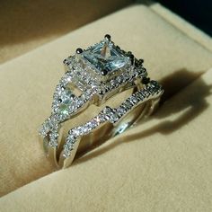 an engagement ring and wedding band set in a box with diamonds on the sides,