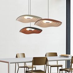 three lights hanging over a table with chairs