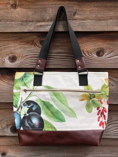 a handbag hanging on the side of a wooden wall with fruit painted on it