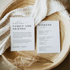 two wedding program cards sitting on top of a wooden bowl next to a white cloth