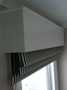 a black and white striped blind hanging from the side of a window in a room