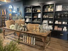 a room filled with lots of vases and shelves full of bottles on top of wooden tables