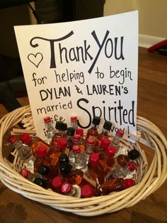 a basket filled with bottles of liquor and a sign that says thank you for helping to begin ryan & lauren's married spirited