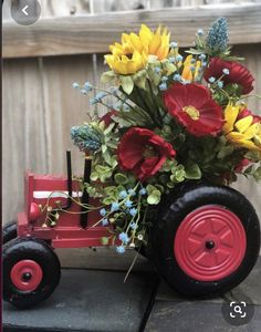 a red toy tractor with flowers in it