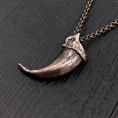 Discover the wild elegance of this unique wolf claw necklace, meticulously cast in solid jeweler's grade bronze from a real North American Gray Wolf claw. Measuring 1-1/4", this piece came from an exceptionally large specimen, making it a rare find. Every intricate detail of the original claw has been captured in this bronze recreation, slightly oxidized to enhance its deep, rich hue. Unlike typical designs, this necklace features a carefully bored hole through the knuckle, allowing the chain to Brass Claw Jewelry As Gift, Medieval Style Hand Cast Bronze Jewelry, Viking Style Bronze Jewelry Gift, Viking Style Hand-forged Jewelry Gift, Hand-forged Viking Style Jewelry Gift, Bronze Engraved Medieval Jewelry, Medieval Engraved Bronze Jewelry, Hand Cast Claw Necklace As Gift, Medieval Brass Jewelry With Antique Finish