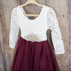 "This dress is just beautiful! It includes a delicate white lace bodice with a deep maroon/burgundy/wine colored skirt. The V Back with unfinished lace adds the perfect amount of boho chic look to this amazing dress. The lace sleeves are finished with the perfect amount of detail. It also includes a rhinestone belt sash that is removable. Perfect for your next special event. We also offer this style in the following colors: Blush Pink: https://www.etsy.com/listing/785978849/white-lace-flower-gir Burgundy Ball Gown, Merlot Dress, Long Sleeve Wedding Gown, Burgundy Flower Girl Dress, Tulle Long Dress, Lace Flower Girl Dress, Long Sleeve Wedding Gowns, Maroon Wedding, Wine Dress