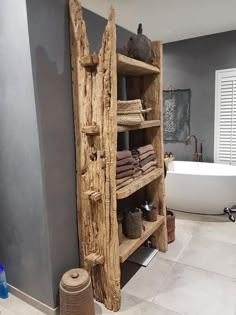 a wooden shelf in the middle of a bathroom next to a bathtub and sink