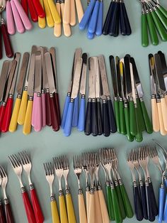 there are many different colored forks and spoons on the table with each one's own