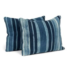 two blue striped pillows sitting on top of each other