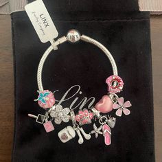 a bracelet with charms on it sitting on top of a black bag