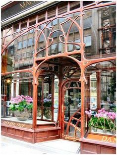 an old fashion store front with flowers in the window