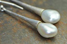 White keshi pearls are paired with a simple long silver dangle. The free form of the natural pearls contrasts beautifully with the simplicity of the silver drops, which flare at the end, as if the pearls emerge from them. The smooth, shimmering luster of the pearls also contrasts with the very textured surface of the sterling silver. I achieve the texture through hammering, and through a mix of matte and polished finishes. A minimalist design with unique details. Perfect for everyday use, a spec Elegant Hammered Teardrop Earrings, Elegant Hammered Teardrop Earrings For Gift, Long Drop Pearl Earrings For Anniversary, Anniversary Long Drop Pearl Earrings, White Drop Pearl Pendant Earrings, White Drop Pearl Earrings With Pendant, Minimalist Long Drop Pearl Pendant Earrings, Minimalist Long Drop Pearl Earrings With Pendant, Minimalist Silver Pearl Drop Earrings