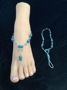 Cloinesse turquoise beads paired with a simple, turquoise, flower bead highlighted with small, shiny beads. Please remember not to wear in the water. Blue Beaded Sandals For Vacation, Summer Beach Anklets With Silver Beads, Bohemian Silver Beads Anklets For Beach, Bohemian Silver Beaded Anklets For Beach, Blue Jewelry With Silver Beads For Summer, Blue Beaded Open Toe Sandals, Adjustable Silver Beads Anklet For Summer, Turquoise Round Beads Anklets For Summer, Blue Beaded Adjustable Sandals