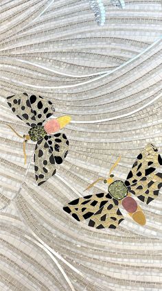 two butterflies are sitting on a glass plate with circles and dots in the middle,