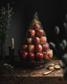 a pile of apples sitting on top of a wooden table