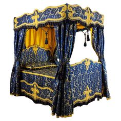 an ornate blue and yellow bed with curtains