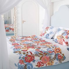 a bed with flowers on it in a bedroom next to a white door and window